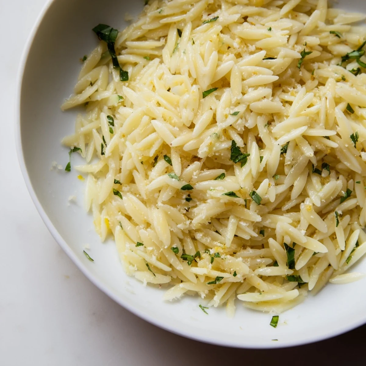 Delicious orzo with lemon, herbs, and Parmesan served in a vibrant bowl.  