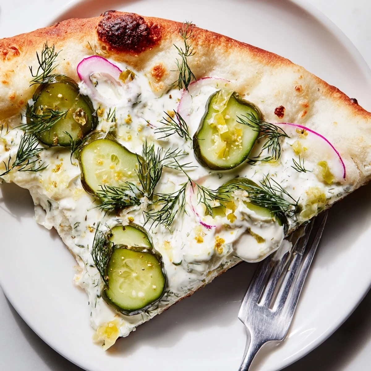 Garnished with fresh dill, a flavorful Pickle Pizza with crunchy pickle slices.  