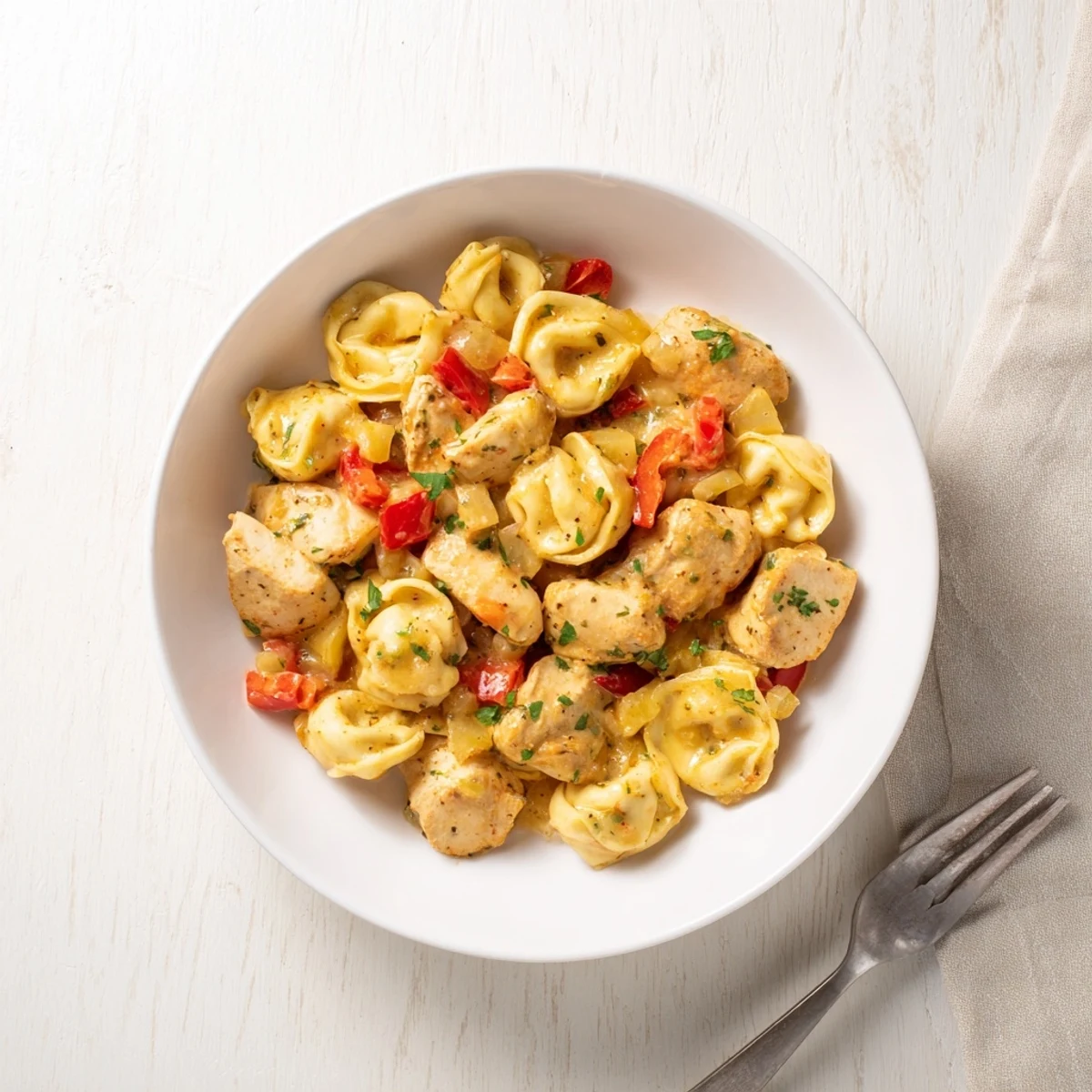 Vibrant Zesty Cajun Garlic Parmesan Chicken Tortellini served with fresh parsley garnish.  