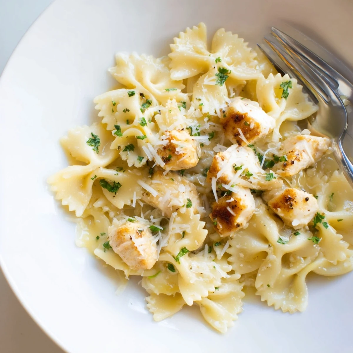 Creamy Mozzarella Garlic Butter Chicken Bowties served with fresh parsley for garnish.  