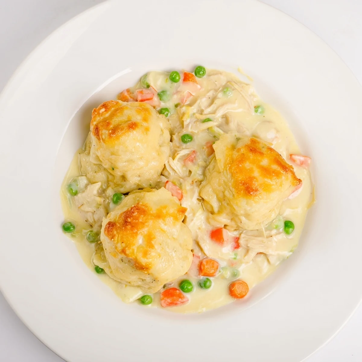 A bubbling Chicken and Dumplings Casserole, showcasing tender chicken pieces under soft, savory dumplings.