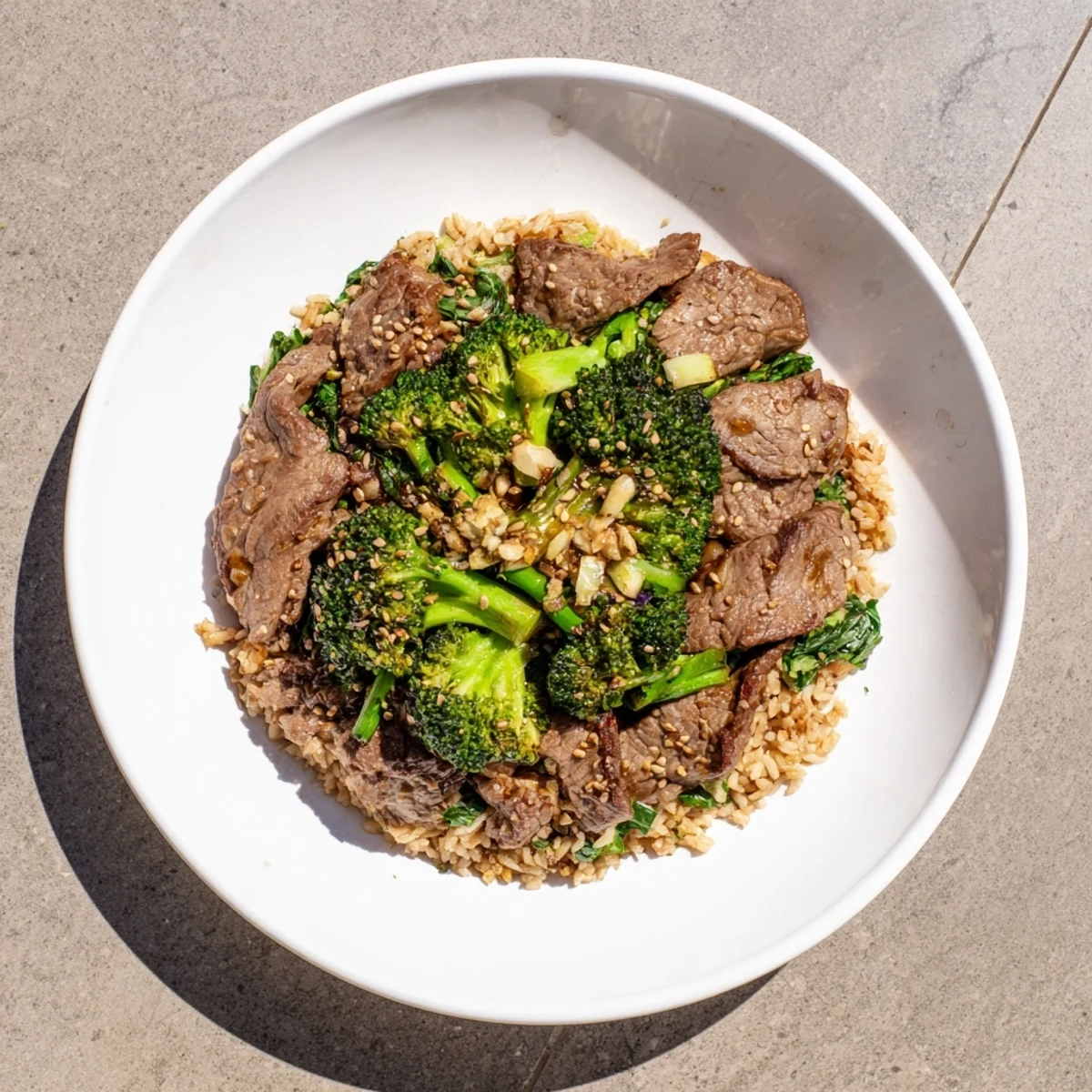 Tender Slow-Cooker Beef & Broccoli with a rich sauce, perfectly over fluffy brown rice and fresh greens.