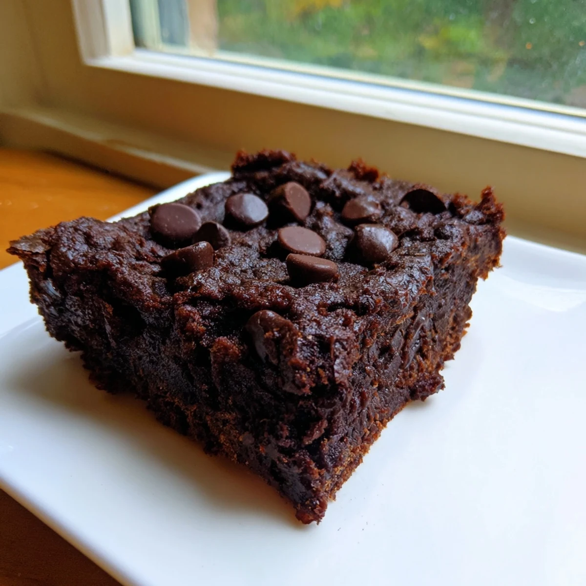 Fudgy Black Bean Brownies, warm from the oven, with a scattering of chocolate chips glistening.