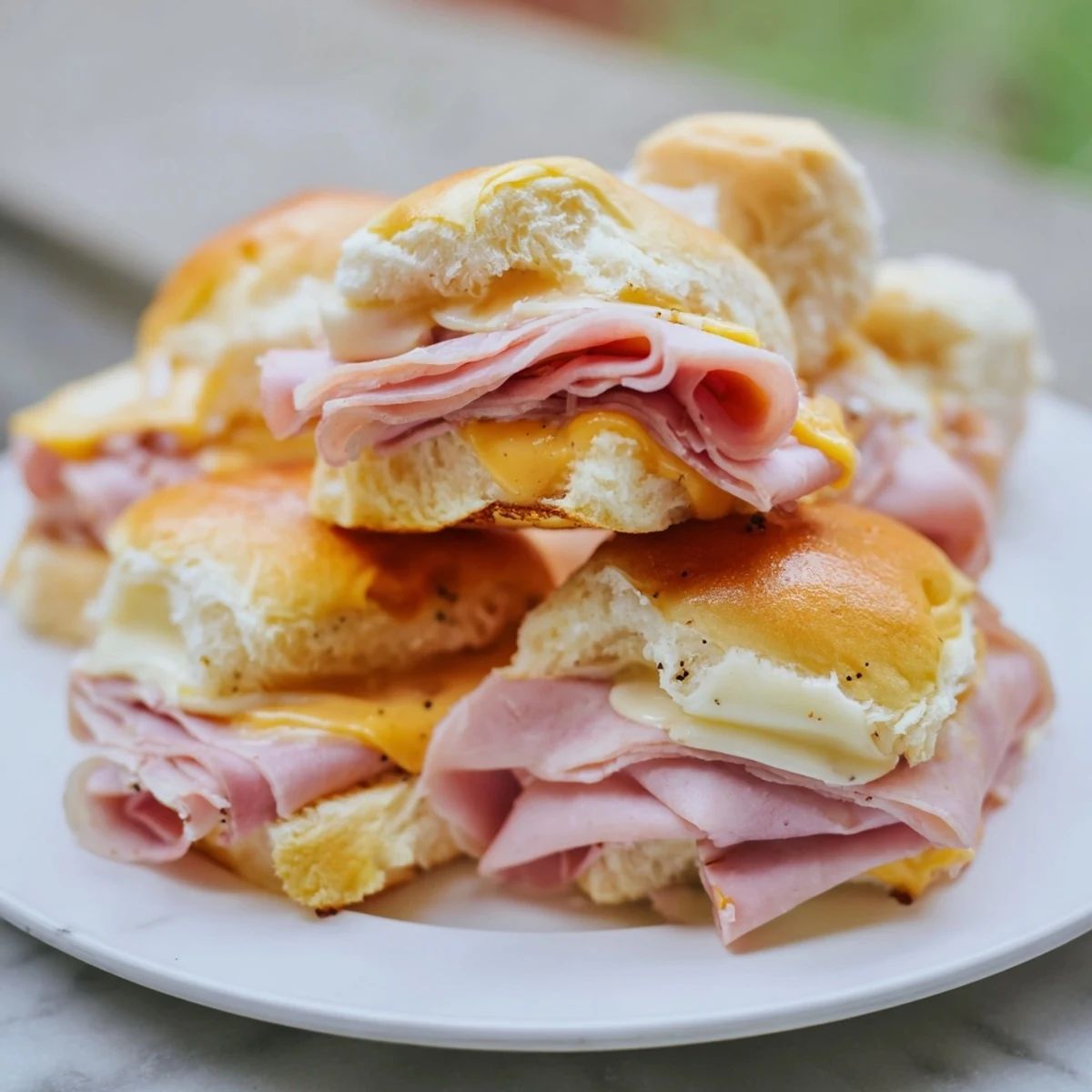 Golden brown crust on a tray of bubbling Budget-Friendly Ham & Cheese Sliders, perfect for sharing.