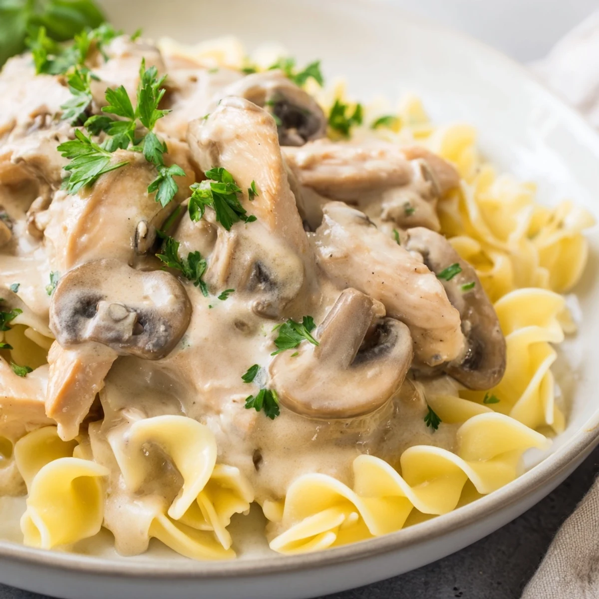 Golden-brown chicken strips and sautéed cremini mushrooms in a creamy paprika sauce served over buttery egg noodles for a comforting Chicken and Mushroom Stroganoff.