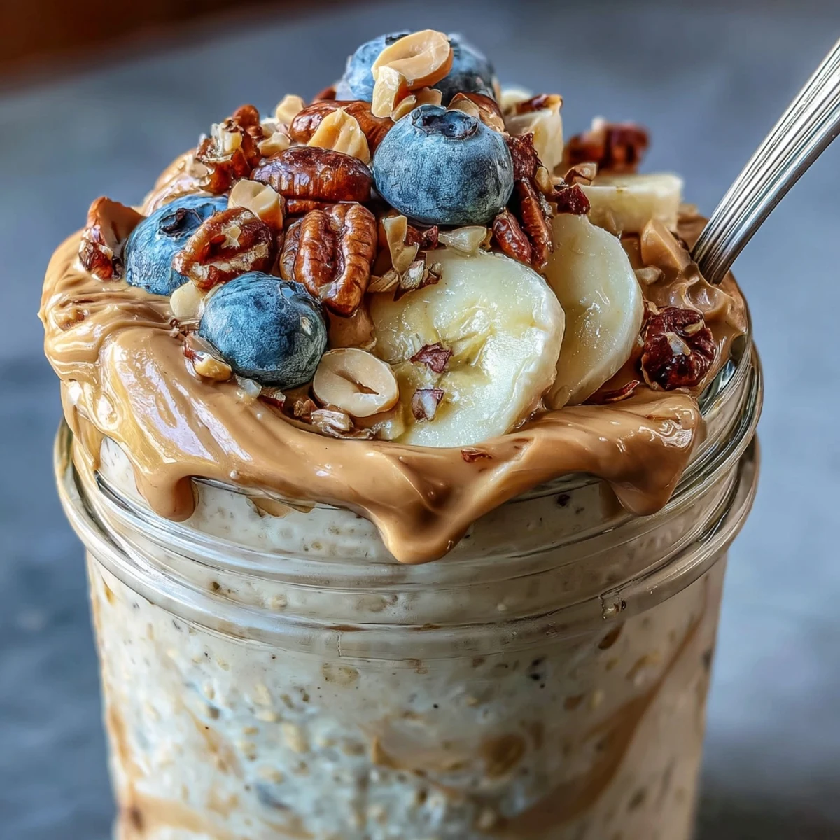 High-Protein Peanut Butter Overnight Oats jar topped with fresh berries and a honey drizzle.