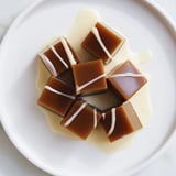 Refreshing coffee jelly cubes shimmering against sweet cream, making an elegant dessert treat.
