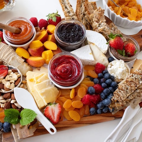 A colorful Jam-Infused Brunch Board with fresh fruits and artisan breads.  