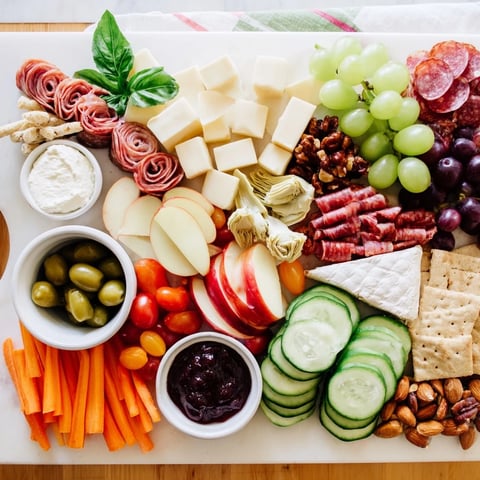 A vibrant girl dinner platter filled with colorful snacks, fruits, and cheeses.  