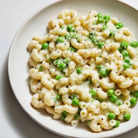 Warm bowl of Macaroni & Peas, creamy and cheesy, ready for a comforting dinner.