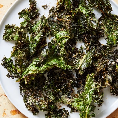 Golden, crispy baked kale chips, a healthy snack with sea salt and pepper seasoning.