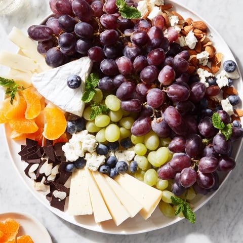 Grapes of Fortune Dessert Board: A colorful array of grapes, cheeses, and treats for a lucky New Year's treat.