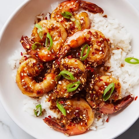 Golden brown Honey Garlic Shrimp glistening in a skillet, ready to serve over fluffy rice.