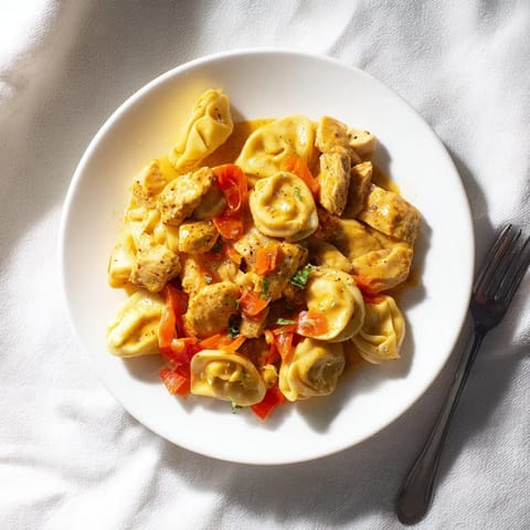 Creamy Cajun garlic Parmesan chicken tortellini with tender pasta and rustic bell peppers.  