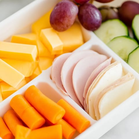 Homemade DIY Lunchables Tray with sliced turkey, ham, cheddar, and grapes, ready to enjoy.