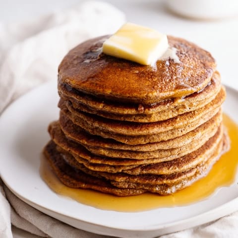 A stack of fluffy Gingerbread Pancakes, smelling of warm spices and ready for a cozy brunch.
