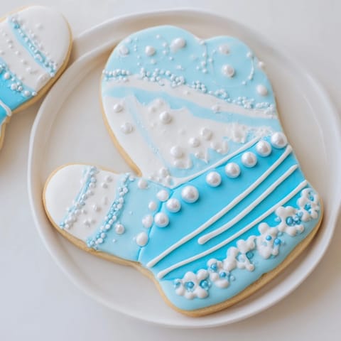 Warm & toasty mitten cookie display: Close-up of frosted mitten cookies showing vibrant colors for winter fun.