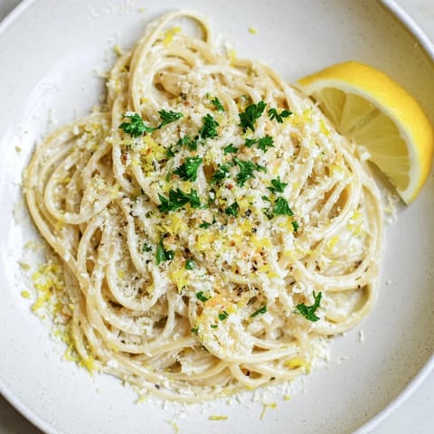 This vibrant bowl of Lemon-Garlic Greek Yogurt Pasta showcases the glossy sauce enveloping the pasta.
