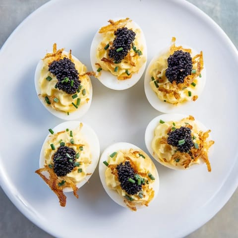Elegant appetizer: creamy deviled eggs topped with glistening caviar and crunchy shallots, delicious!