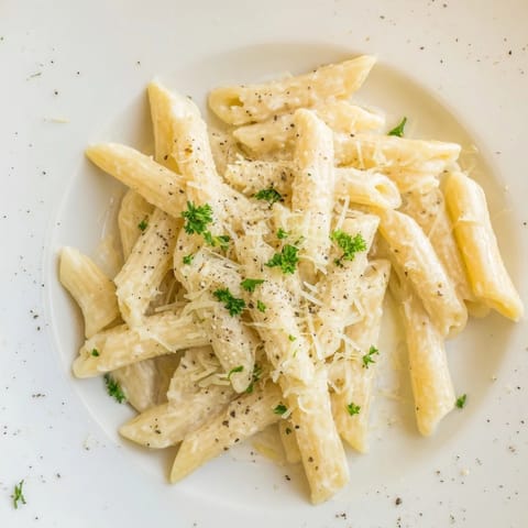 This Creamy Milk Pasta One-Pot recipe shows golden penne pasta in a smooth, cheesy dairy sauce with herbs.