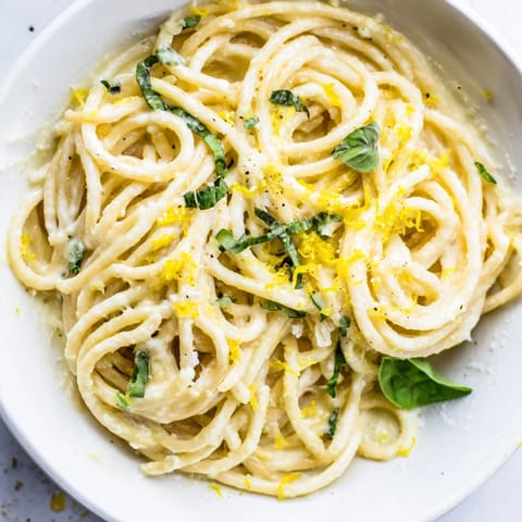 Lemon Ricotta Pasta in a white bowl, garnished with fresh basil, grated Parmesan, and extra lemon zest for a bright finish.  