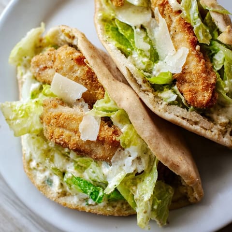 Golden brown crispy chicken strips, chopped romaine lettuce, and shaved Parmesan packed inside a warm pita with extra drizzle.