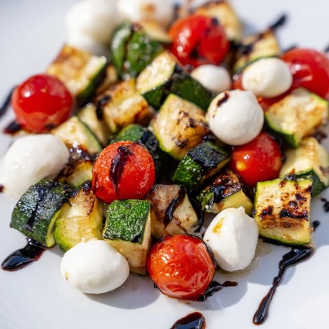 Roasted zucchini, bell peppers, and onions are tossed with mozzarella and a sweet-tangy balsamic glaze in this colorful Italian-inspired salad.