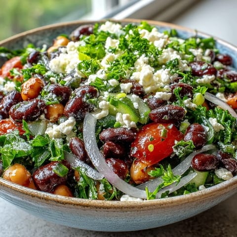 A chilled bowl of Divorce Salad featuring marinated beans, tangy feta, and thinly sliced red onion for crunch.