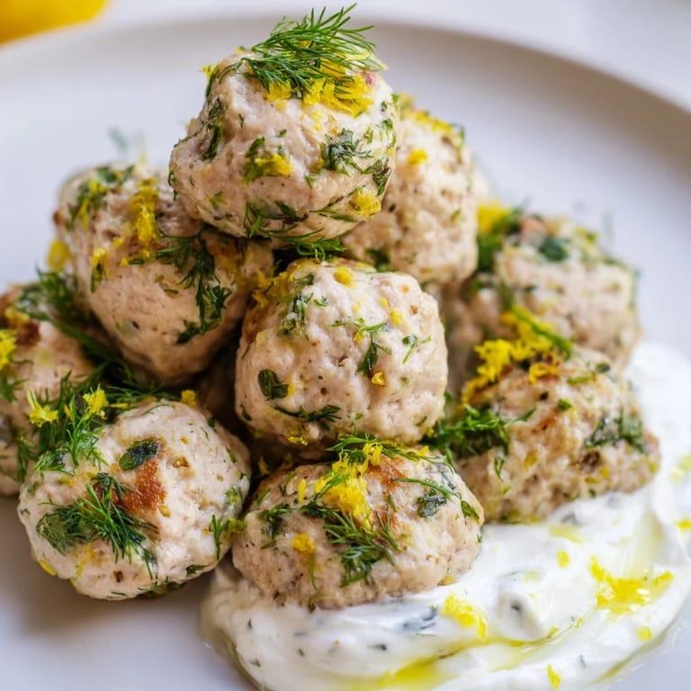 Golden-brown Greek chicken meatballs bursting with fresh herbs, perfect with zesty yogurt dip.  