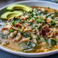 Hearty bowl of white bean chicken chili with tender shredded chicken and creamy cannellini beans.