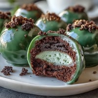 Vibrant green Oreo truffle balls with creamy filling, coated in smooth white chocolate and festive sprinkles.