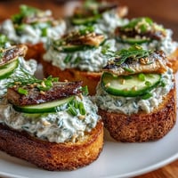 Golden crispy rice sardine toasts topped with fresh cucumber and chives.