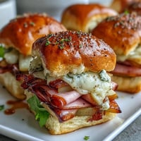Melted Swiss cheese oozes over ham and pear in baked Pear Ham and Cheese Lunchbox Sliders.